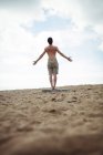 Вид ззаду чоловіка, що стоїть на пляжі — стокове фото