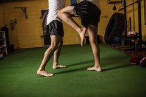 Sección baja de boxeadores tailandeses practicando boxeo en gimnasio - foto de stock
