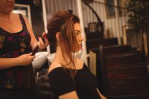 Jovem morena styling seu cabelo no salão de beleza — Fotografia de Stock