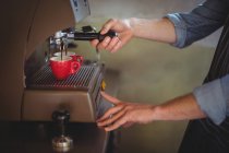 Mid section of waiter making coffee in cafe at workshop — Stock Photo