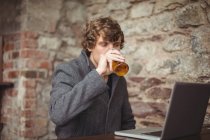 Homem usando laptop no bar — Fotografia de Stock