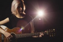 Студентка играет на гитаре в студии — стоковое фото