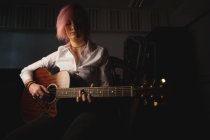 Mujer tocando una guitarra en la escuela de música - foto de stock