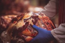 Close-up de açougueiros mão segurando carne vermelha embalada — Fotografia de Stock