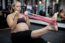 Schwangere trainiert mit Widerstandsband in Turnhalle — Stockfoto