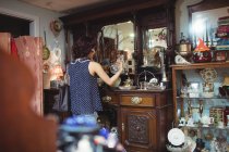 Rückansicht einer Frau beim Antiquitäteneinkauf im Antiquariat — Stockfoto