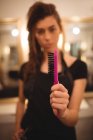 Friseurin mit Haarbürste im Salon — Stockfoto