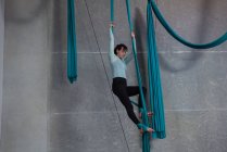 Ginnasta che si allena su corda di tessuto blu in palestra — Foto stock