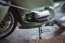 Мойка мотоцикла с мойкой под давлением в мастерской — стоковое фото