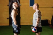 Dos boxeadores de pie cara a cara en el gimnasio - foto de stock