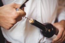 Середня секція барного тендера, що відкриває пляшку вина за барною стійкою — стокове фото