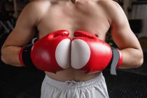 Midsection of boxer in boxing gloves at fitness studio — Stock Photo