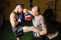 Vue grand angle de deux boxeurs thaïlandais pratiquant dans la salle de gym — Photo de stock