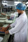 Жіночий персонал кладе яєчну коробку на конвеєр на яєчну фабрику — стокове фото
