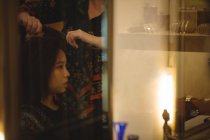 Woman getting hair straightened at hair saloon — Stock Photo