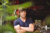 Portrait de bar tendre debout avec bras croisés au comptoir de bar — Photo de stock