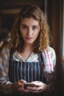 Портрет красивой официантки с помощью мобильного телефона в мастерской — стоковое фото
