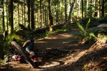 Male cyclist getting injured while falling from mountain bike in park — Stock Photo