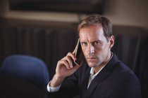 Ritratto di un uomo d'affari che parla al cellulare in ufficio — Foto stock