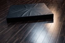 Ginástica esteira de aterragem no chão de madeira no estúdio de fitness — Fotografia de Stock