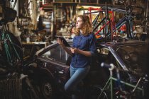 Mechaniker mit digitalem Tablet bei Reparatur von Fahrrad in Werkstatt — Stockfoto