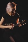 Жінка грає на гітарі в музичній школі — стокове фото