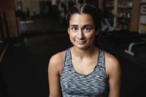 Porträt einer lächelnden Sportlerin, die im Fitnessstudio in die Kamera blickt — Stockfoto