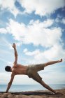 Людина, що здійснює йога на пляжі — стокове фото