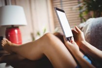 Frau nutzt digitales Tablet im heimischen Wohnzimmer — Stockfoto