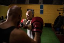 Selective focus of two thai boxers practicing boxing in gym — Stock Photo