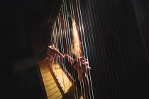 A meio da seção da mulher tocando uma harpa na escola de música — Fotografia de Stock
