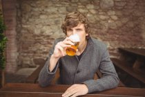 Портрет мужчины, пьющего пиво в баре — стоковое фото