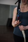 Turnerin befestigt Gurtzeug am Seil im Fitnessstudio — Stockfoto