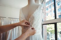 Stilista femminile che regola il vestito su un manichino in studio — Foto stock