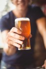Крупний чоловік тримає скляні пивом у барі — стокове фото
