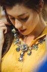 Женщина в винтажном ожерелье в антикварном магазине — стоковое фото