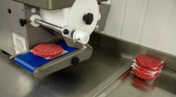 Proceso de preparación de hamburguesas crudas en la carnicería - foto de stock