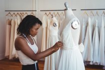 Modedesignerin justiert Kleid an Schaufensterpuppe im Atelier — Stockfoto
