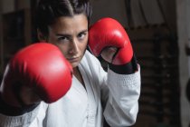 Retrato de mujer con guantes de boxeo en el gimnasio - foto de stock