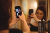Женщина делает селфи с мобильного телефона в салоне — стоковое фото