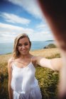 Камера точка зрения улыбающейся женщины, стоящей в поле — стоковое фото