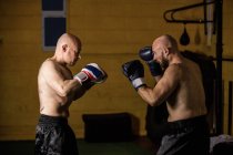 Seitenansicht zweier muskulöser thailändischer Boxer beim Training im Fitnessstudio — Stockfoto