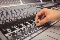 Hand of a female student using sound mixer in a studio — Stock Photo