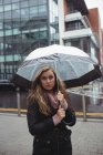 Портрет красива жінка тримає парасольку під час сезону дощів на вулиці — стокове фото