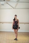 Bailarina de pé em estúdio e olhando para a câmera — Fotografia de Stock