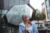Riendo atractiva mujer disfrutando de la lluvia durante la temporada de lluvias - foto de stock