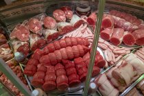 Variedad de filetes laminados en exhibición en carnicería - foto de stock