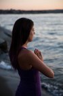 Красивая женщина медитирует на пляже вечером — стоковое фото