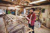 Чоловік готує дерев'яну раму човна на човні — стокове фото