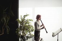Aufmerksame Frau spielt Klarinette in Musikschule — Stockfoto